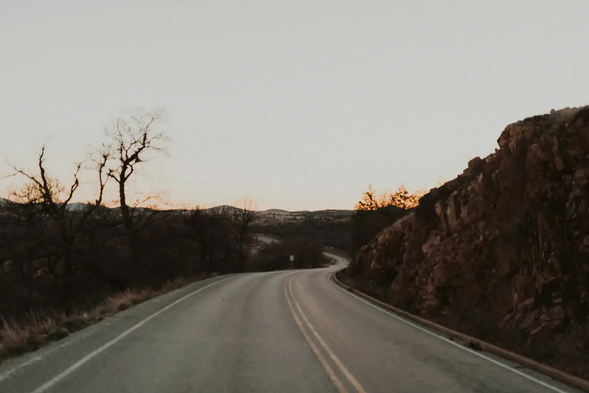 Empty Oklahoma highway stretching toward the horizon at sunset