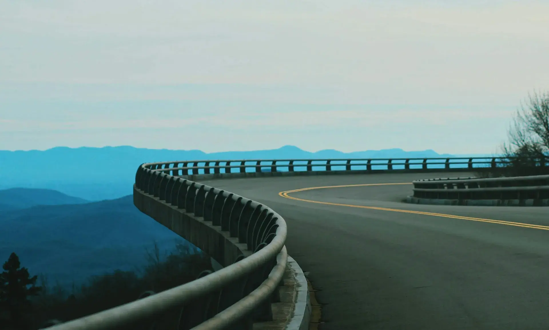 Blue Ridge Parkway curving along a guardrail with mountains in the distance
