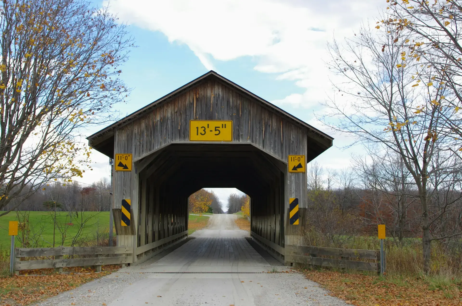 Road running through a red wooden covered bridge in Ashtabula County, Ohio