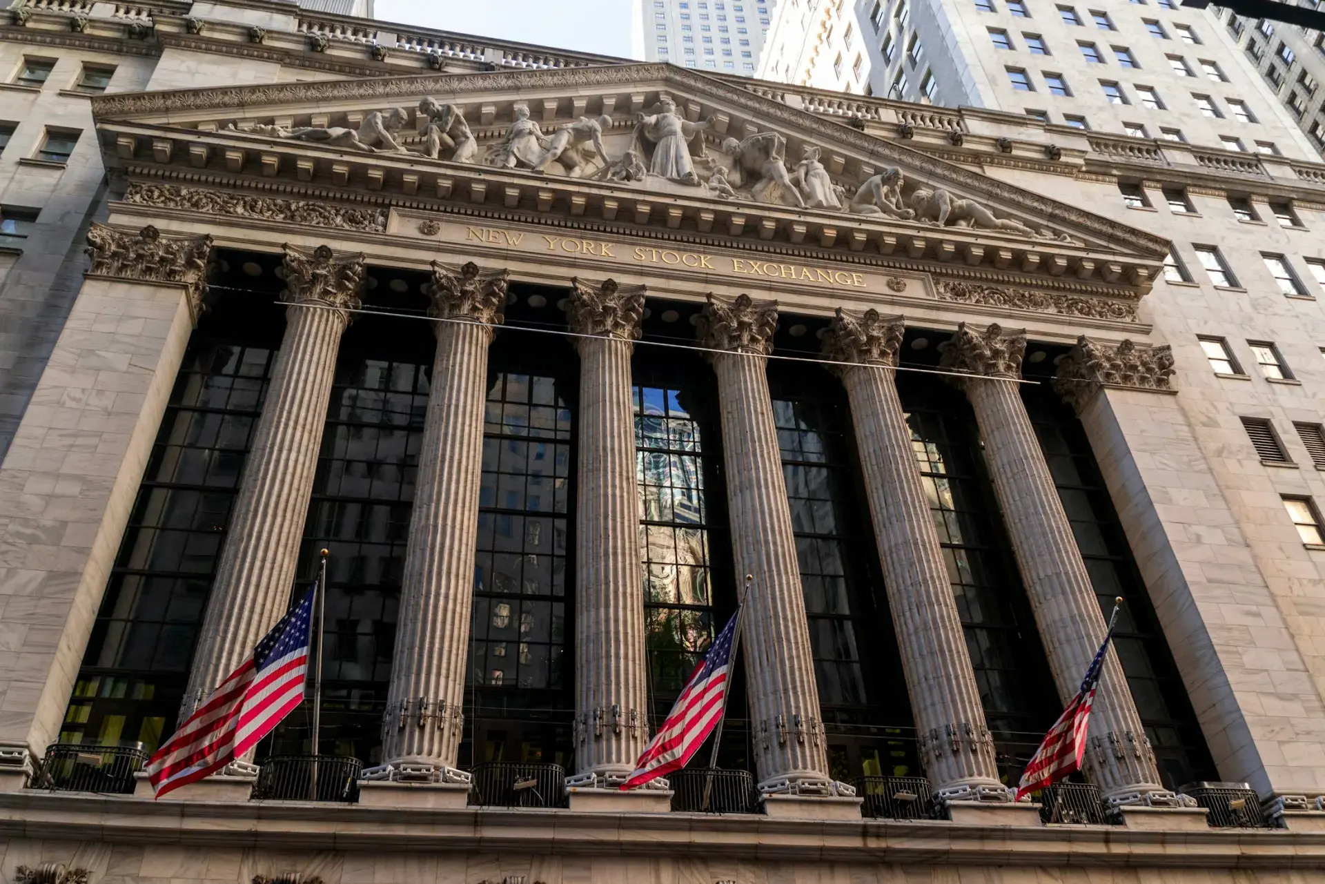 Columns of the New York Stock Exchange building with American flags flying